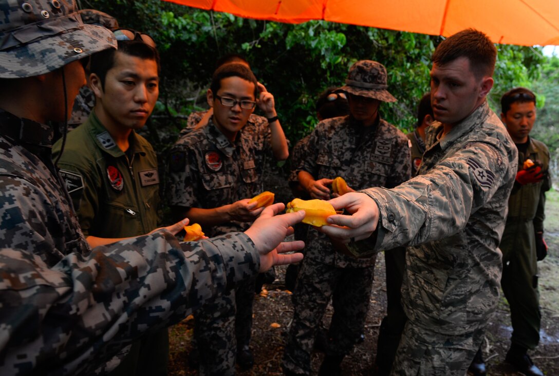 Staff Sgt. Levi Wood, survival, evasion, resistance and escape instructor assigned to the 353rd Combat Training Squadron, shares star fruit with Japan Air Self-Defense Force airmen during a jungle survival workshop Feb. 16, 2016, at Andersen Air Force Base, Guam. Exercise Cope North 16 includes 22 total flying units and nearly 3,000 personnel from six countries and continues the growth of strong, interoperable and beneficial relationships within the Indo-Asia-Pacific region through integration of airborne and land-based command and control assets. (U.S. Air Force photo by Staff Sgt. Alexander W. Riedel/Released)