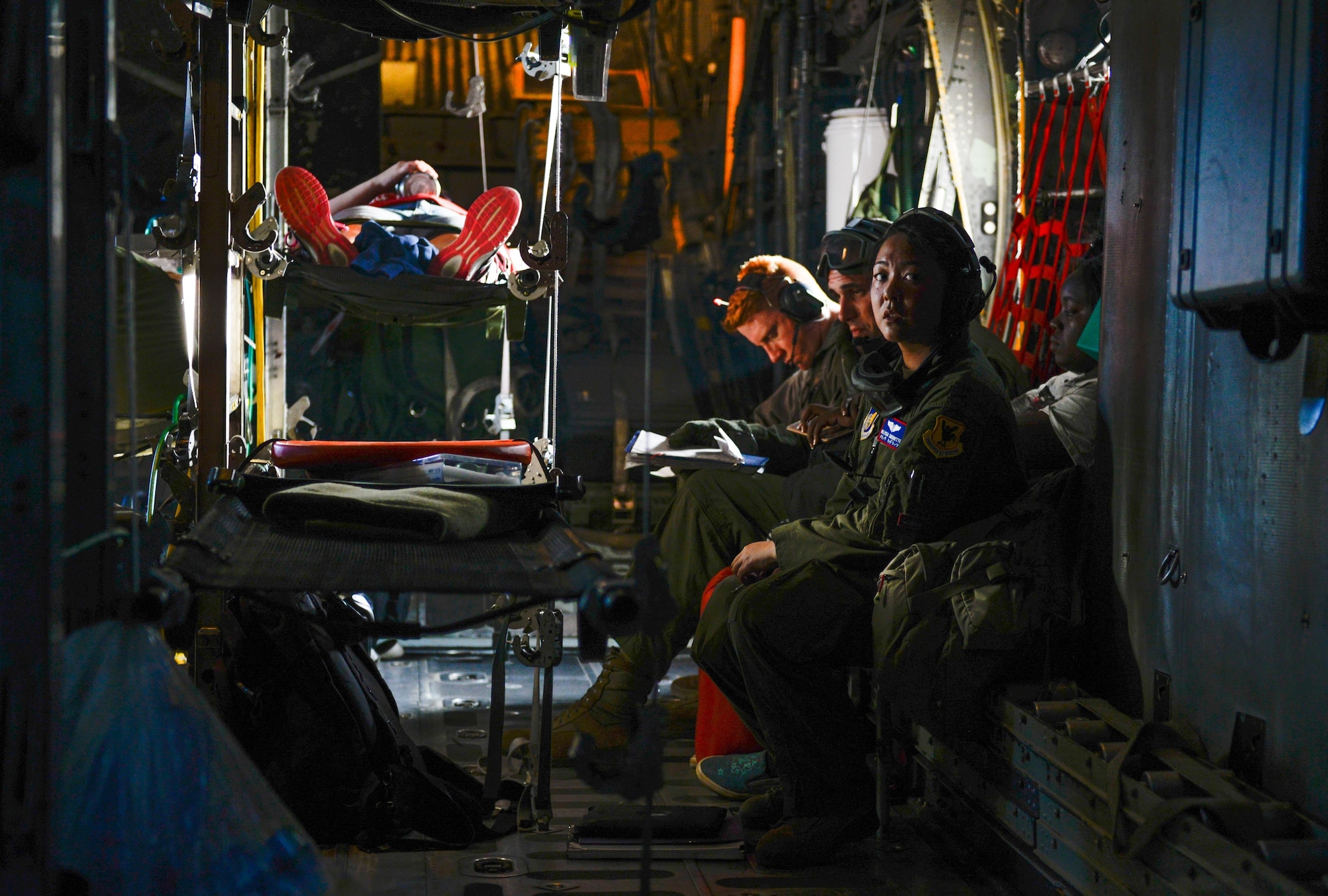 Capt. Melissa Cadorette, a flight nurse with the 18th Aeromedical Evacuation Squadron, listens to crew communications aboard a U.S. Air Force C-130 Hercules Feb. 15, 2016, during an expeditionary medical support exercise on the island of Rota. Exercise Cope North 16 enhances humanitarian assistance and disaster relief crisis response capabilities between six nations and lays the foundation for regional cooperation during real-world contingencies in the Indo-Asia-Pacific region. (U.S. Air Force photo by Staff Sgt. Alexander W. Riedel/Released)