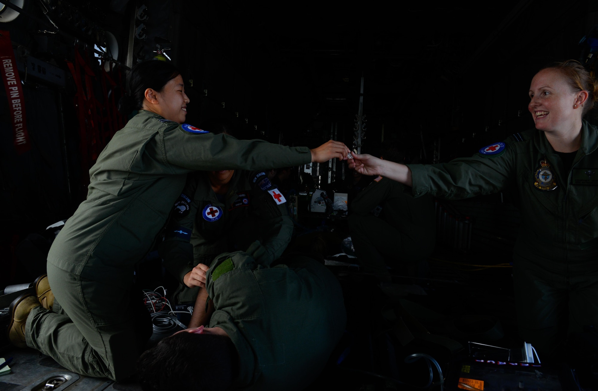 Royal Australian Air Force Leading Aircraftwoman Chantel Gibson, a flight medic, right, hands medical supplies Flt. Lt. Maggy Wong, a flight nurse, during a medical transfer training Feb. 17, 2016, at Andersen Air Force Base, Guam. Exercise Cope North 16 enhances humanitarian assistance and disaster relief crisis response capabilities between six nations and lays the foundation for regional cooperation expansion during real-world contingencies in the Indo-Asia-Pacific Region. The MH-60S is assigned to Helicopter Sea Combat Squadron 25. Wong and Gibson are assigned to RAAF No. 3 Aero-Medical Evacuation Squadron. (U.S. Air Force photo by Staff Sgt. Alexander W. Riedel/Released)