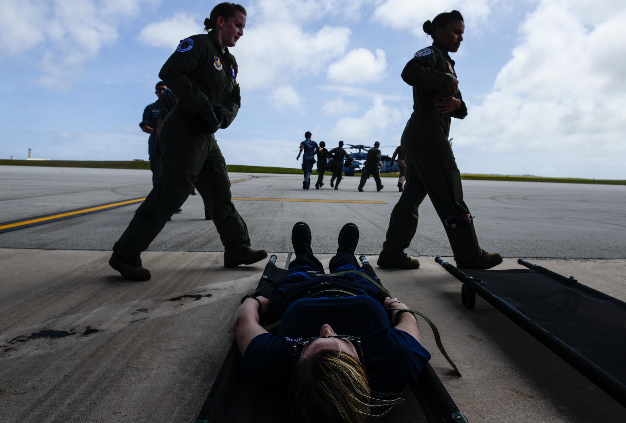 A patient with simulated injuries lies waiting while U.S. Air Force and Japan Air Self-Defense Force aeromedical evacuation crews prepare for a patient transfer Feb. 17, 2016, at Andersen Air Force Base, Guam. Exercise Cope North 16 enhances humanitarian assistance and disaster relief crisis response capabilities between six nations and lays the foundation for regional cooperation expansion during real-world contingencies in the Indo-Asia-Pacific Region. (U.S. Air Force photo by Staff Sgt. Alexander W. Riedel/Released)