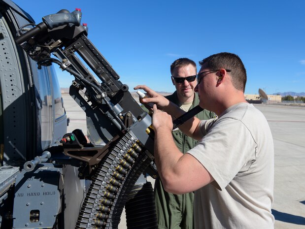 Master Sgt. Bishop Bailey, 176th Aircraft Maintenance Squadron weapons section chief from Joint Base Elmendorf-Richardson, Alaska, sprays lubricant on a GAU-18.50 machine during preflight inspections at Nellis Air Force Base, Nev., Feb. 11, 2016, . The HH-60 Pave Hawk provides the capability of independent rescue operations in combat areas up to and including medium-threat environments. (U.S. Air Force photo by Airman 1st Class Nathan Byrnes)