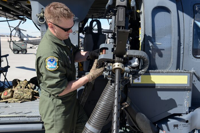 Airman 1st Class David Hayes, 210th Rescue Squadron special missions aviator assigned to Joint Base Elmendorf- Richardson, Alaska, performs preflight checks on a GAU-18.50 caliber machinegun at Nellis Air Force Base, Nev., Feb. 11, 2016. The HH-60 Pave Hawk core mission is recovery of personnel under stressful conditions, including search and rescue. (U.S. Air Force photo by Airman 1st Class Nathan Byrnes)