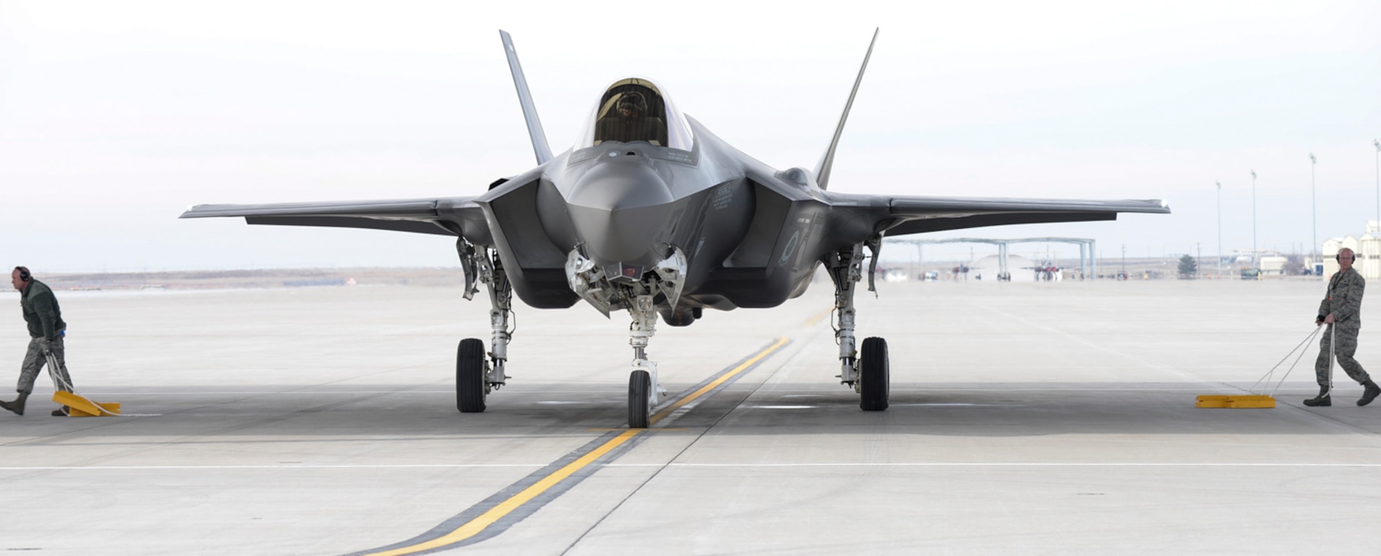 Two airmen remove the chalks from an F-35A preparing for departure from Mountain Home Air Force Base, Idaho, Feb. 12, 2016. The F-35 is a 5th generation multi-role fighter with stealth, electronic warfare and multi-spectral fused sensor capabilities needed to achieve unmatched levels of survivability and lethality in a contested environment. (U.S. Air Force photo by Airman 1st Class Jessica H. Evans/RELEASED)