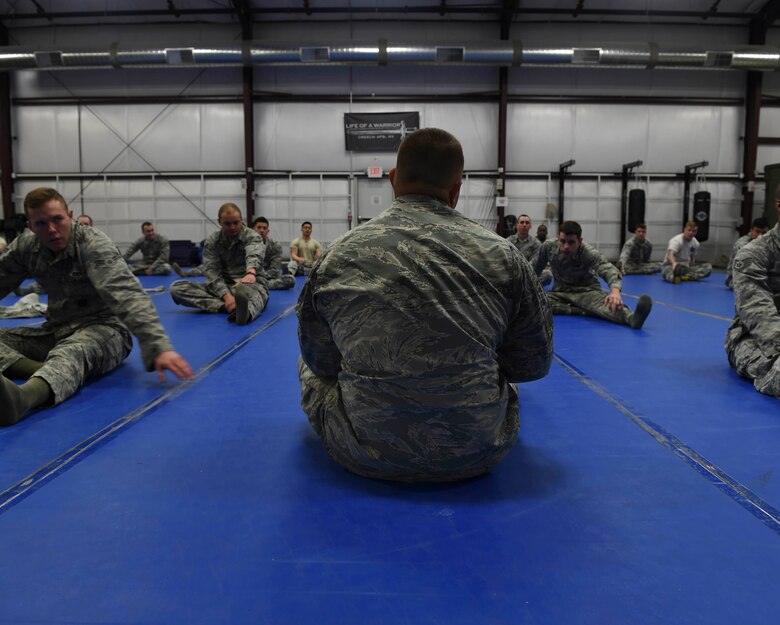Tech Sgt. Christopher 799th Security Forces Squadron flight sergeant, leads a stretching exercise before training Feb. 19, 2016, at Creech Air Force Base, Nevada. To prevent injuries SFS Airmen stretch prior to beginning their weekly combatives training. (U.S. Air Force photo by Senior Airman Adarius Petty/Released)