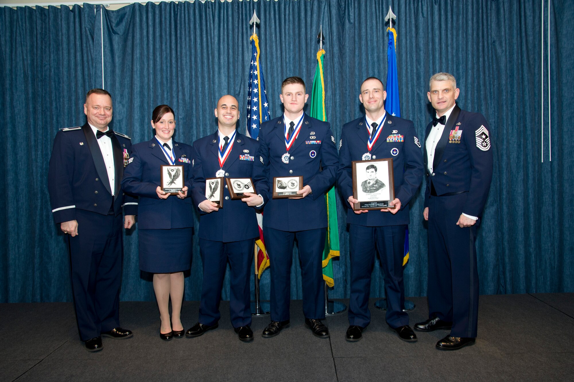 Airmen who earned top honors pose for a photo with Col. Brian McDaniel, 92nd Air Refueling Wing commander, and Chief Master Sgt. Christian Pugh, 92nd ARW command chief, Feb. 18, 2016, at Fairchild Air Force Base, Wash. Airman Leadership School is a five-week course that focuses on leadership abilities, profession of arms and effective communication in the workplace.