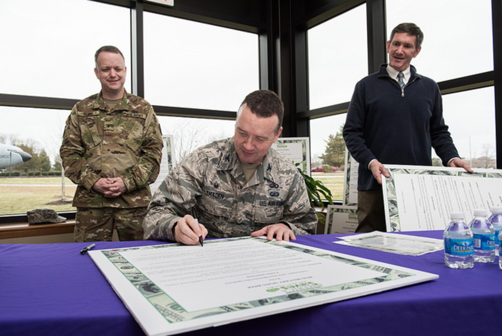 Col. Frederick D. Thaden, Joint Base McGuire-Dix-Lakehurst and 87th Air Base Wing commander, signs the Military Saves Proclamation as Col. Mark Towne, Joint Base Deputy commander, and Mr. Timothy Simmons, 87th Force Support Squadron lead for personnel finance, looks on. The Military Saves Kickoff week promotes the importance of saving, investing, and thinking about the military member’s financial future. (U.S. Air Force photo by Russ Meseroll/Released)
