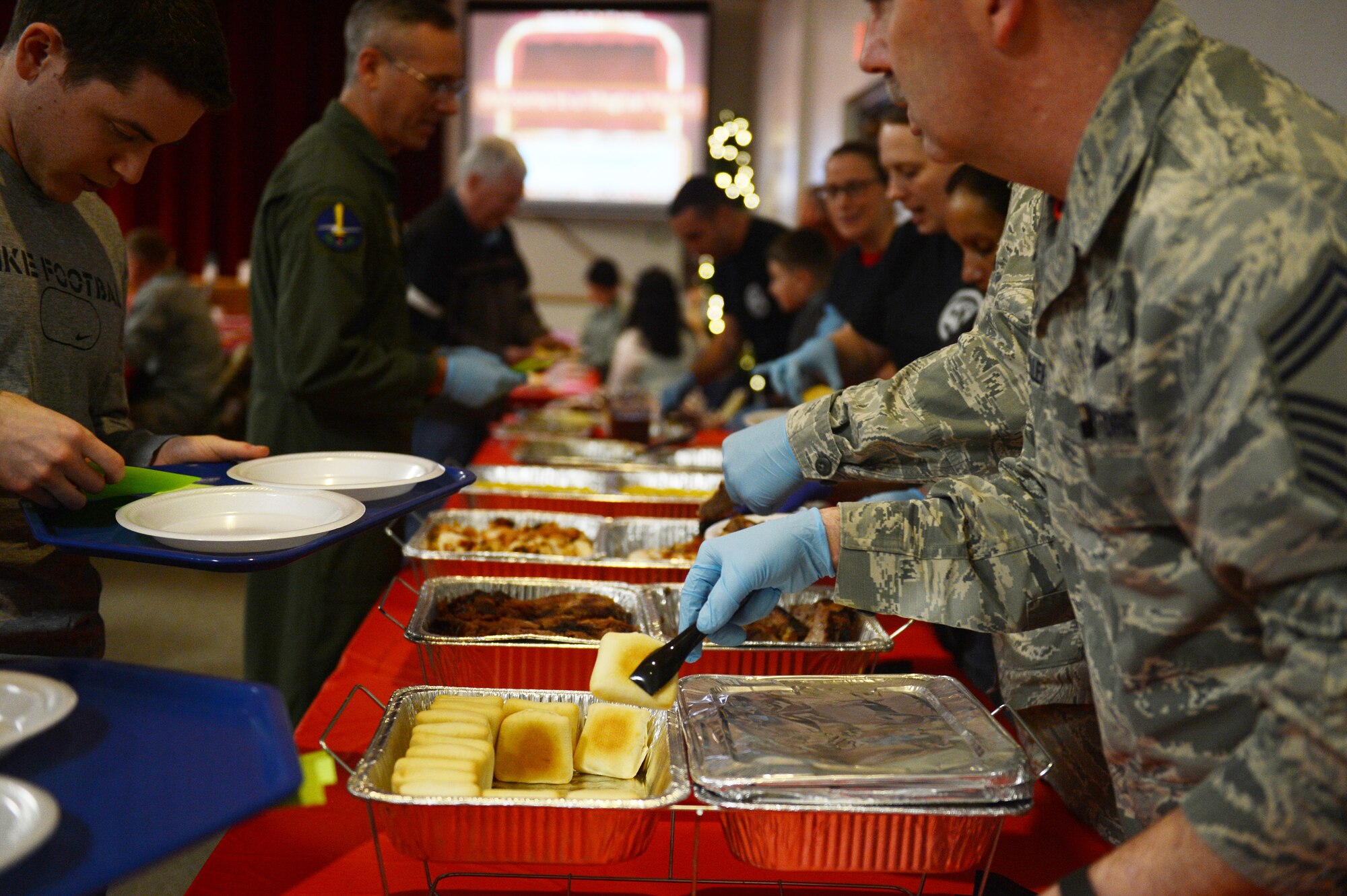 Team McChord leadership and volunteer’s, serve food to the families attending the Team McChord Deployed Family Dinner Feb. 19, 2016, at the Chapel Support Center on Joint Base Lewis-McChord, Wash. More than 70 family members of deployed service members came out to the event. (U.S. Air Force photo/Senior Airman Divine Cox)