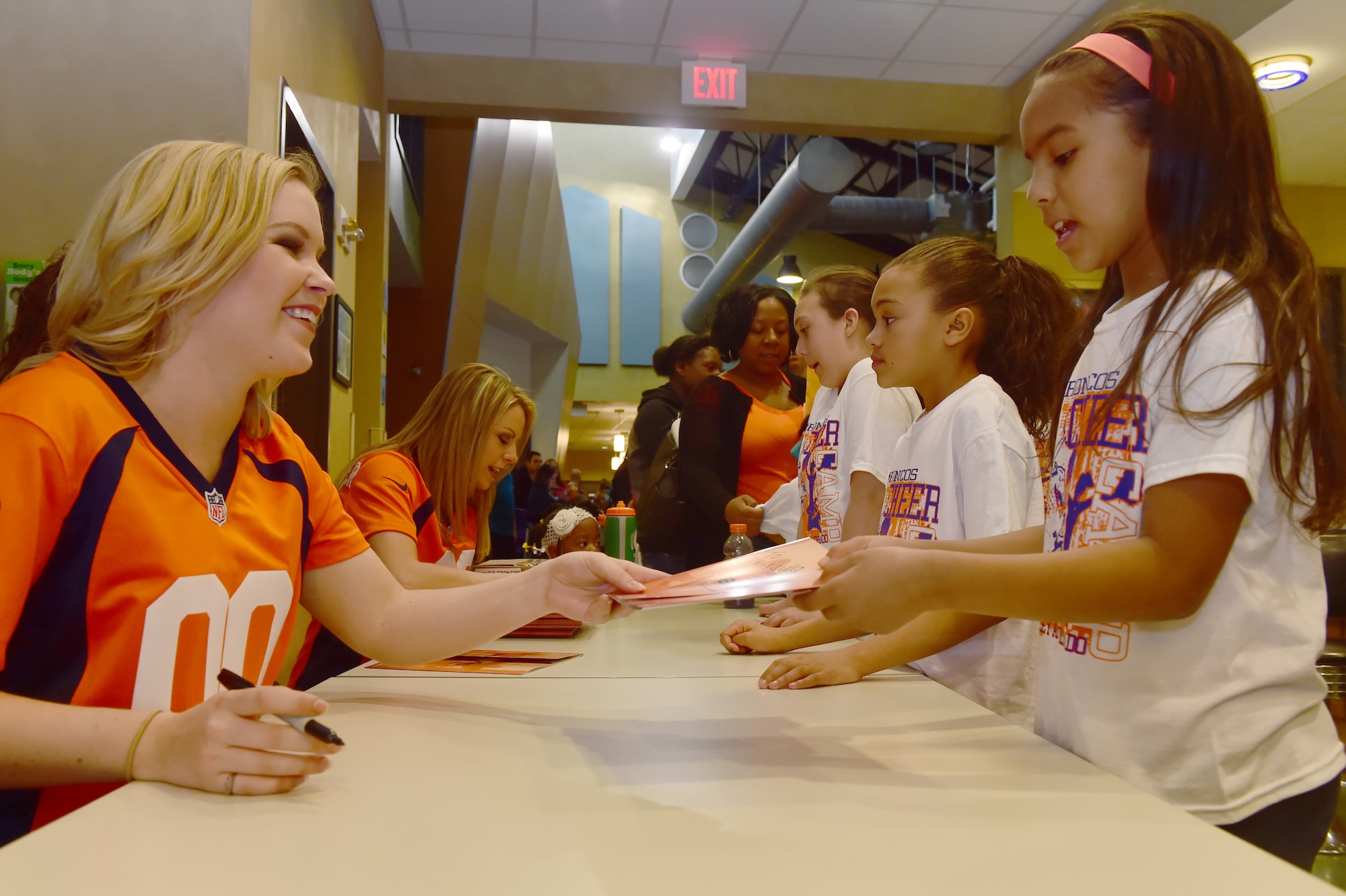 Denver Broncos cheerleaders sign autographs at the Buckley Youth Center Feb. 20, 2016, on Buckley Air Force Base, Colo. The Broncos cheerleaders held a cheer clinic as part of an initiative to increase opportunities for military youth to participate in fitness programs which was coordinated by the Buckley Youth Center along with the Broncos organization. The Air Force Services Agency Child and Youth Programs helped fund the clinic, which 65 children between the ages of 6 and 18 took part in.  (U.S. Air Force photo by Airman 1st Class Luke W. Nowakowski/Released) 