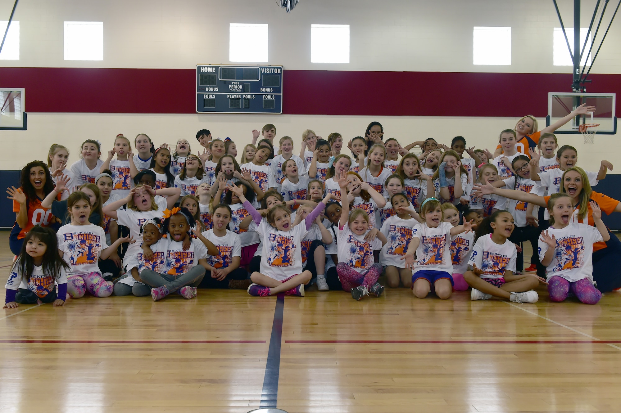 Children from the Buckley community, along with Denver Broncos cheerleaders, pose for a group photo at the Buckley Youth Center Feb. 20, 2016, on Buckley Air Force Base, Colo. The cheerleaders held a cheer clinic as part of an initiative to increase opportunities for military youth to participate in fitness programs which was coordinated by the Buckley Youth Center along with the Broncos organization. The Air Force Services Agency Child and Youth Programs helped fund the clinic, which 65 children between the ages of 6 and 18 took part in.  (U.S. Air Force photo by Airman 1st Class Luke W. Nowakowski/Released)