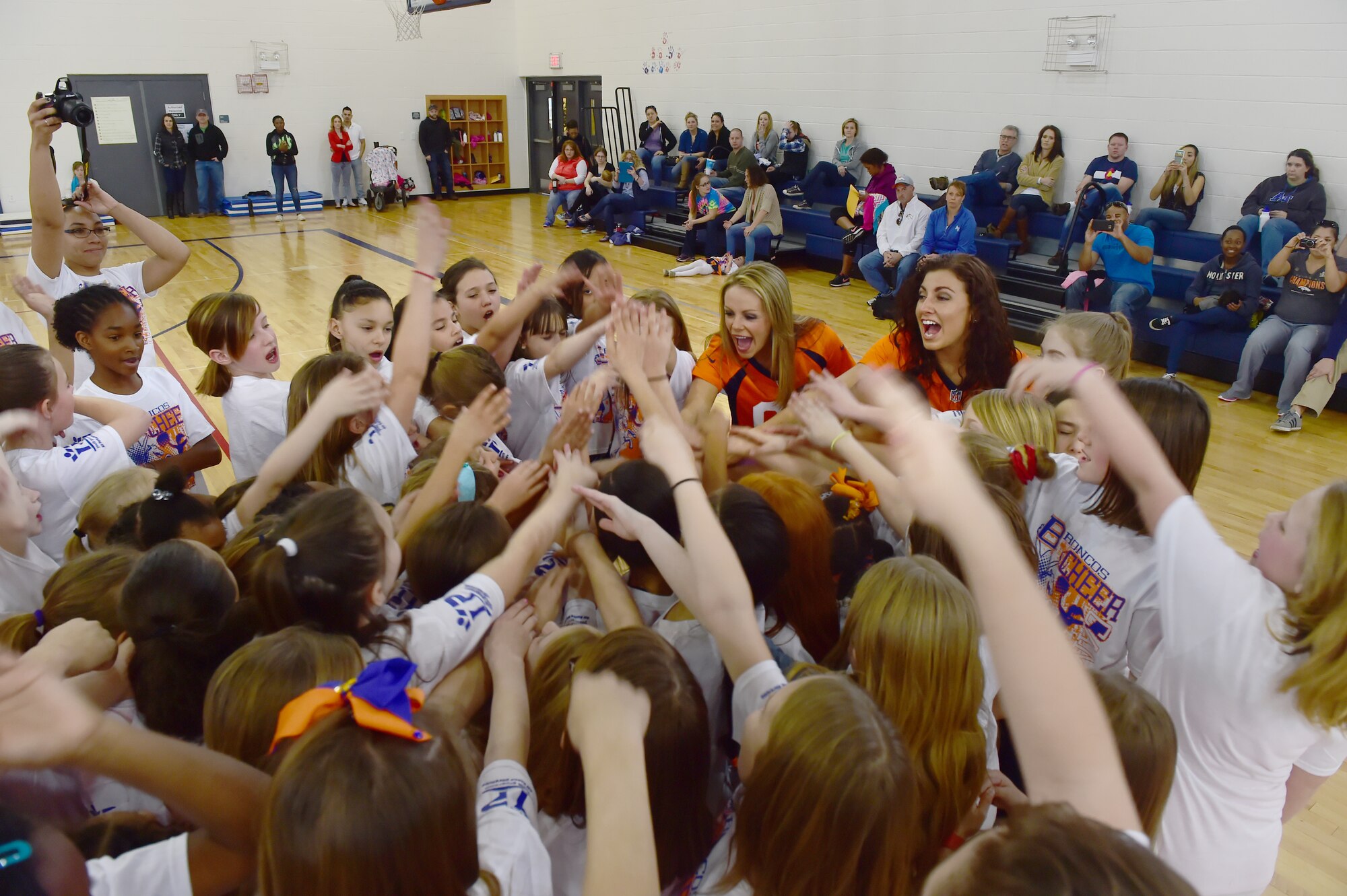 Denver Broncos cheerleaders lead a cheer at the Buckley Youth Center Feb. 20, 2016, on Buckley Air Force Base, Colo. The cheerleaders held a cheer clinic as part of an initiative to increase opportunities for military youth to participate in fitness programs which was coordinated by the Buckley Youth Center along with the Broncos organization. The Air Force Services Agency Child and Youth Programs helped fund the clinic, which 65 children between the ages of 6 and 18 took part in.  (U.S. Air Force photo by Airman 1st Class Luke W. Nowakowski/Released)