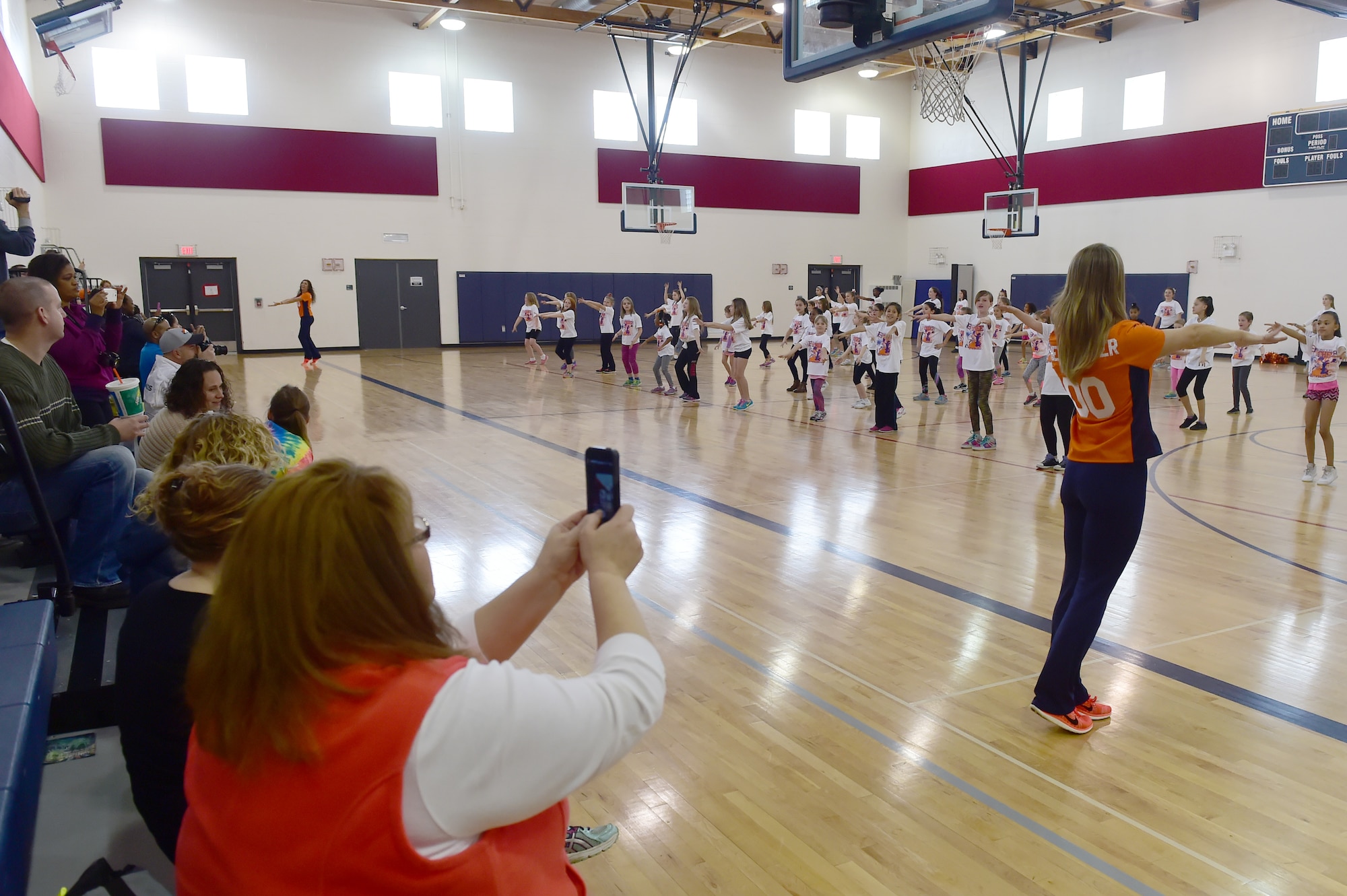 Parents watch their children perform a choreographed dance at the Buckley Youth Center Feb. 20, 2016, on Buckley Air Force Base, Colo. The Denver Broncos cheerleaders held a cheer clinic as part of an initiative to increase opportunities for military youth to participate in fitness programs which was coordinated by the Buckley Youth Center along with the Broncos organization. The Air Force Services Agency Child and Youth Programs helped fund the clinic, which 65 children between the ages of 6 and 18 took part in.  (U.S. Air Force photo by Airman 1st Class Luke W. Nowakowski/Released)