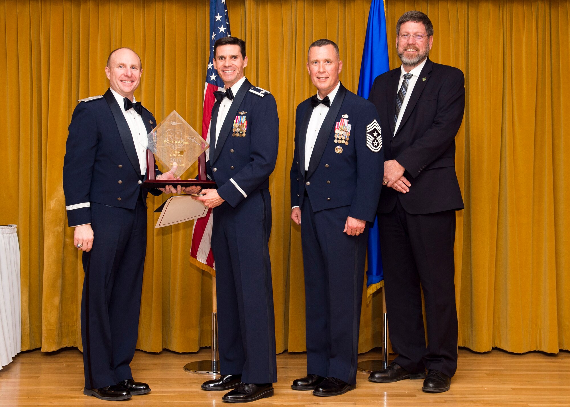 Lt. Col. Eric Bippert (second from left), 418th Flight Test Squadron commander, accepts the award for 2015 Team of the Year for the KC-46 tanker program team. (U.S. Air Force photo by Ethan Wagner)
