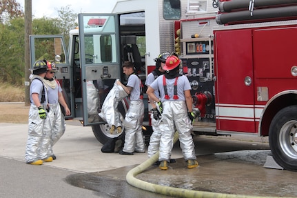 SOTO CANO AIR BASE, Honduras - Firefighters with the 612th Air Base Squadron, conduct an equipment check before entering a simulated structural fire during a monthly familiarization and proficiency exercise, Feb. 18, 2016, at Soto Cano Air Base, Honduras. The firefighters take part in these exercises on a regular basis to maintain their ability to respond to different emergency situations and keep their knowledge and response procedures up-to-date. (U.S. Army photo by Maria Pinel) 