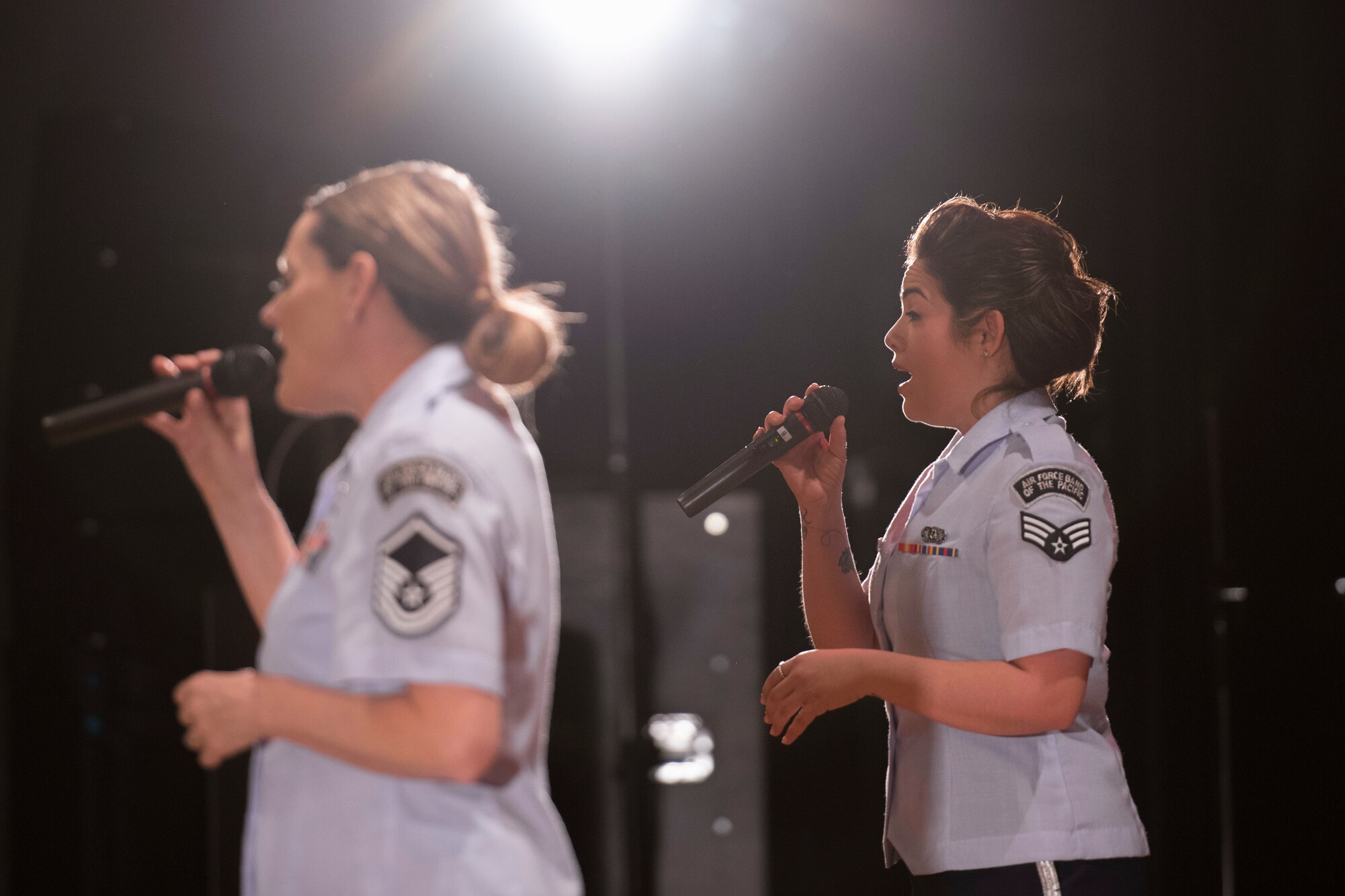 Senior Airman Maritzaida Amador and Master Sgt. Julie Bradley, both from the Air Force Band of the Pacific-Asia, sing to the crowd during the Japan-U.S. Joint Concert at Kotori Hall in Akishima, Tokyo, Japan, Feb. 20, 2016. The North Kanto Defense Bureau hosted the event to help foster better relationships between Japanese and U.S. members. (U.S. Air Force photo by Staff Sgt. Michael Washburn/Released)