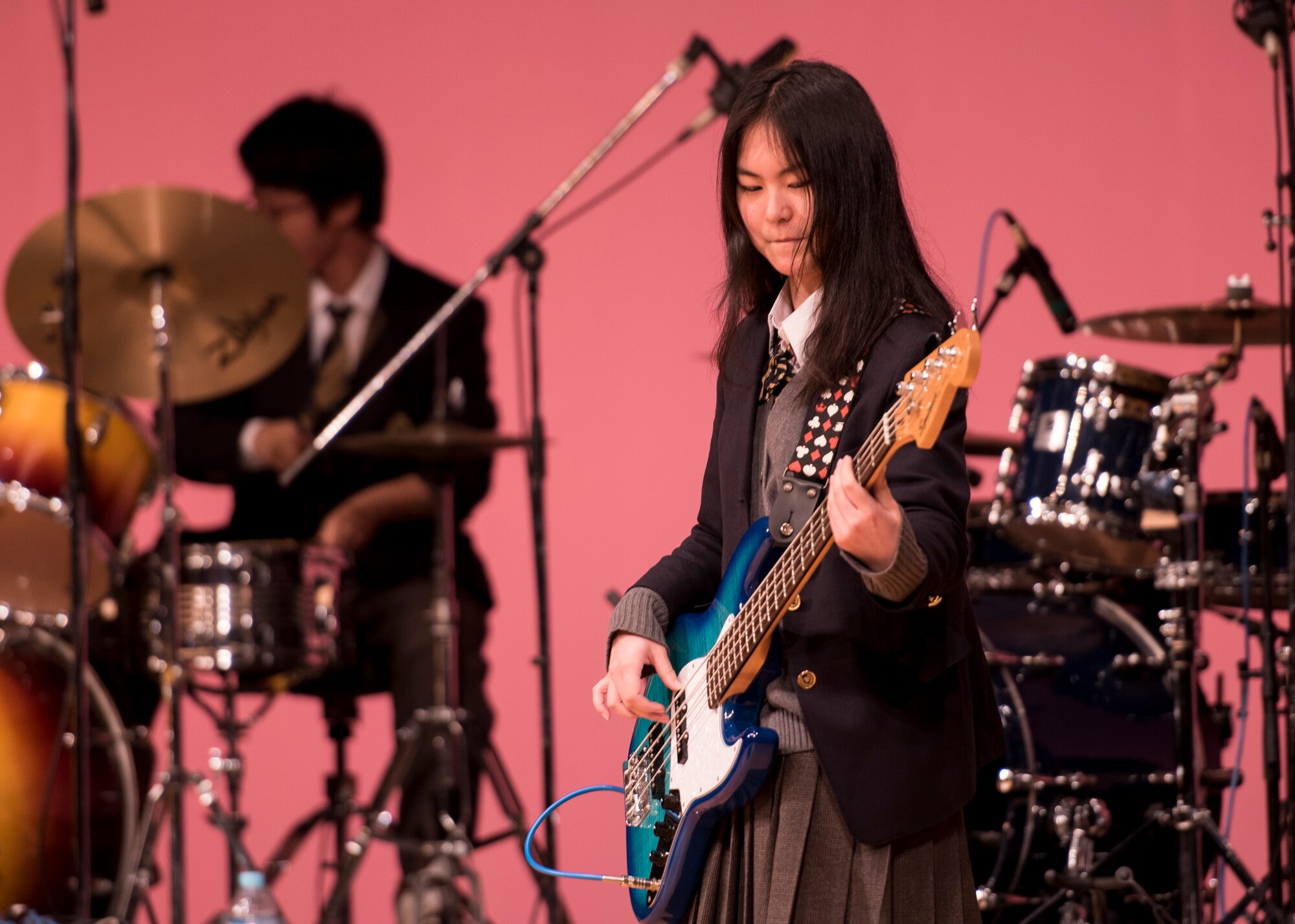 A band member from the Tokyo Metropolitan Haijima High School Light Music Club plucks her bass guitar during the Japan-U.S. Joint Concert at Kotori Hall in Akishima, Tokyo, Japan, Feb. 20, 2016. The North Kanto Defense Bureau hosted the event to help foster better relationships between Japanese and U.S. members. (U.S. Air Force photo by Staff Sgt. Michael Washburn/Released)