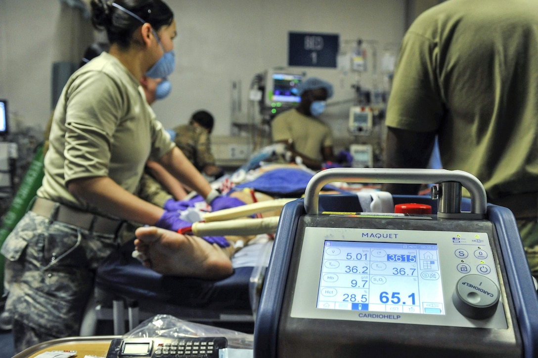 Airmen work with members of the Extracorporeal Membrane Oxygenation team to save the life of a NATO service member at the Craig Joint-Theater Hospital on Bagram Airfield, Afghanistan, Feb. 18, 2016. The airmen are assigned to the 455th Expeditionary Medical Group. The ECMO team, dispatched from San Antonio Military Medical Center, uses technology that bypasses the lungs and infuses the blood directly with oxygen, while removing the harmful carbon dioxide from the blood stream. The patient was airlifted to Landstuhl Regional Medical Center, Germany, where he will receive 7 to 14 days of additional ECMO treatment. Air Force photo by Tech. Sgt. Nicholas Rau