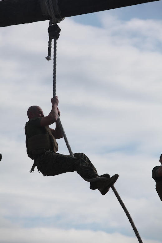 Sergeant Maj. Rogelio Deleon climbs up a rope while maneuvering the obstacle course at Marine Corps Air Station Cherry Point, N.C., Feb. 17, 2016. More than 85 noncommissioned officers with Marine Wing Communications Squadron 28 participated in the physical training exercise “Chaos,” which tested their warfighting abilities: strength, communication and dependability. During the training the Marines were put into fire teams where they had to navigate the obstacle course, trek through the combat pool and hike one-mile with a simulated casualty and assault load. The purpose of the event was to build on unit cohesion, esprit de corps and mental and physical resiliency.  Deleon is the sergeant major of MWCS-28.