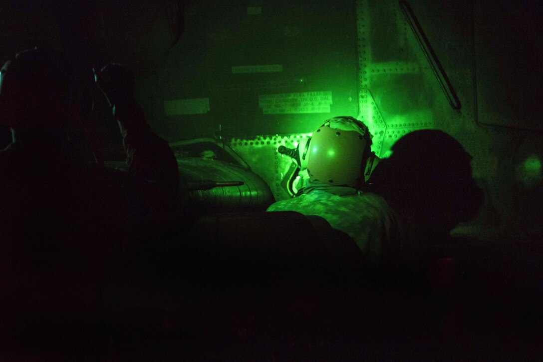 As seen through a night-vision device, a soldier refuels an AH-64 Apache helicopter during an aerial gunnery exercise on Fort A.P. Hill, Va., Feb. 16, 2016.  Army photo by Staff Sgt. Christopher Freeman