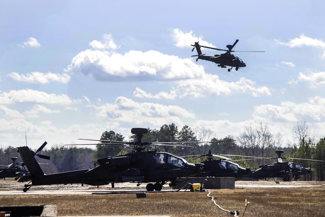 An AH-64 Apache helicopter flies over other Apaches en route to an aerial gunnery exercise on Fort A.P. Hill, Va., Feb. 17, 2016. Army photo by Staff Sgt. Christopher Freeman