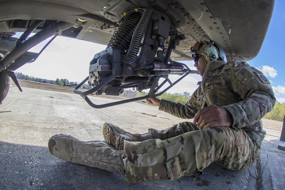 Army Sgt. Nandolall works on a 30 mm machine gun before the AH-64 Apache helicopter participates in an aerial gunnery exercise on Fort A.P. Hill, Va., Feb. 17, 2016. Nandolall is a helicopter mechanic assigned to the 82nd Airborne Division’s 82nd Combat Aviation Brigade, 1st Attack Reconnaissance Battalion. Army photo by Staff Sgt. Christopher Freeman