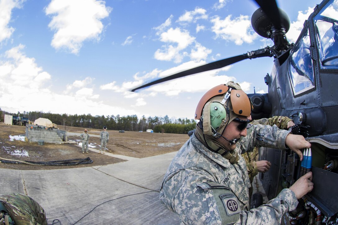 Army Spc. Minton loads 30 mm machine gun rounds onto an AH-64 Apache helicopter during an aerial gunnery exercise on Fort A.P. Hill, Va., Feb. 17, 2016. Minton is assigned to the 82nd Airborne Division’s 82nd Combat Aviation Brigade, 1st Attack Reconnaissance Battalion. Army photo by Staff Sgt. Christopher Freeman