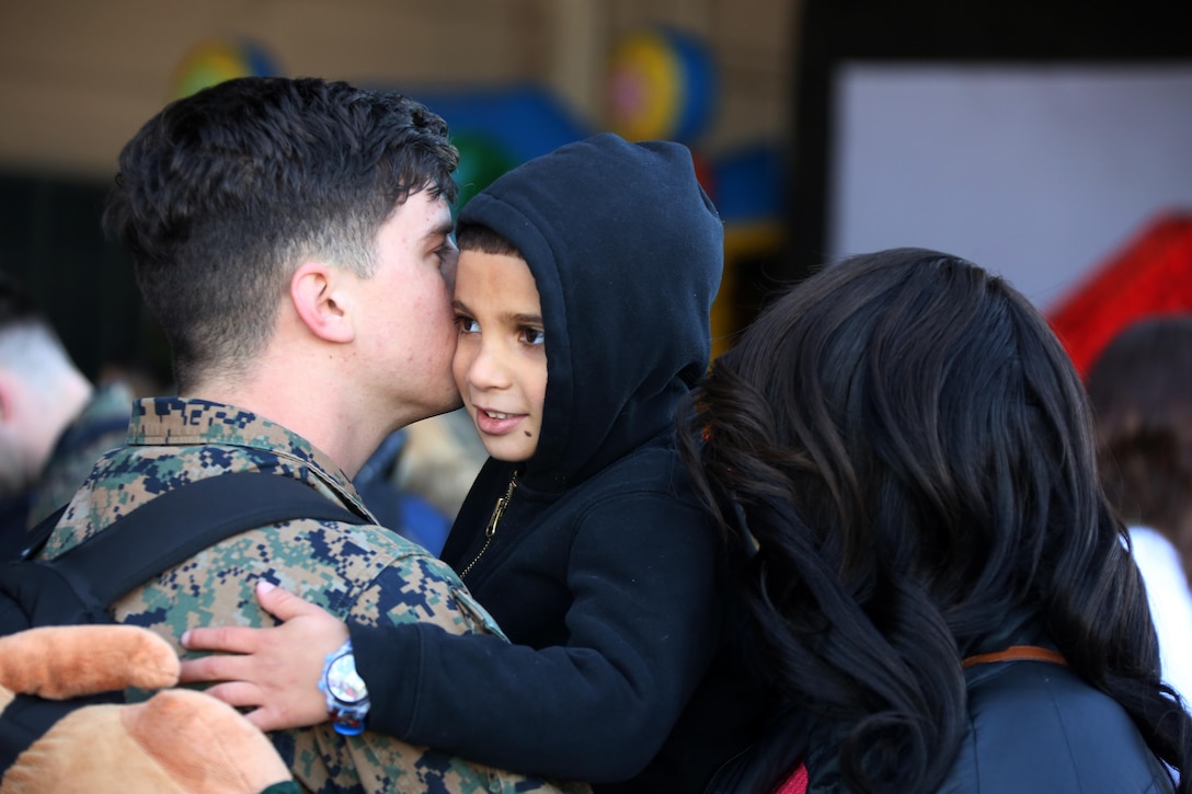 A Marine is reunited with his family during a homecoming ceremony at Marine Corps Air Station Cherry Point, N.C., Feb. 11, 2016. Marines and Sailors with Marine Tactical Electronic Warfare Squadron 3 returned to the air station after a six-month deployment in support of the United States Pacific Command combatant commander, Marine Aircraft Group 12, 1st Marine Aircraft Wing with EA-6B expeditionary electronic warfare capabilities. (U.S. Marine Corps photo by Cpl. N.W. Huertas/Released)