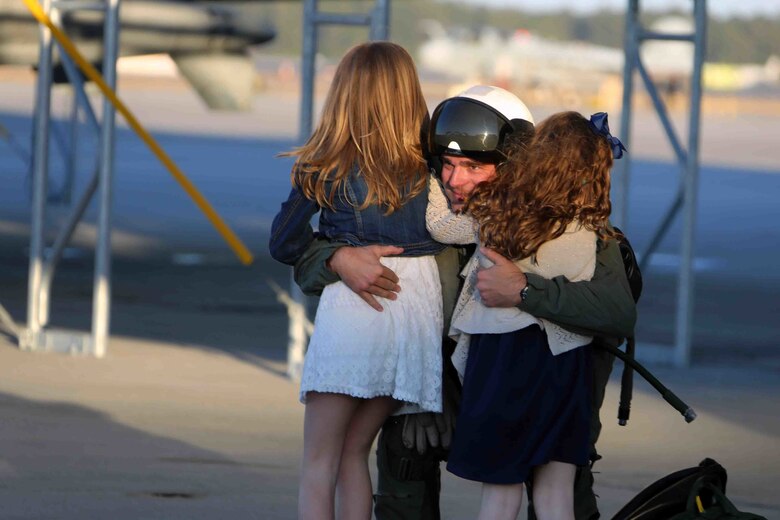 Captain Timothy Thornton embraces his daughters during a homecoming ceremony at Marine Corps Air Station Cherry Point, N.C., Feb. 16, 2016. Marines and Sailors with Marine Tactical Electronic Warfare Squadron 3 returned to the air station after a six-month deployment in support of the United States Pacific Command combatant commander, Marine Aircraft Group 12, 1st Marine Aircraft Wing with EA-6B expeditionary electronic warfare capabilities. Thornton is a mobility officer with the squadron. (U.S. Marine Corps photo by Cpl. N.W. Huertas/Released)