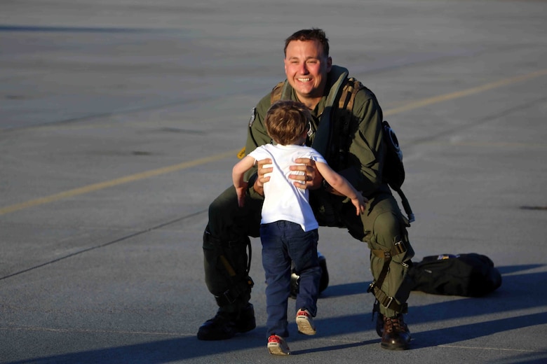 Captain Adam Chase picks up his son Logan during a homecoming ceremony at Marine Corps Air Station Cherry Point, N.C., Feb. 16, 2016. Marines and Sailors with Marine Tactical Electronic Warfare Squadron 3 returned to the air station after a six-month deployment in support of the United States Pacific Command combatant commander, Marine Aircraft Group 12, 1st Marine Aircraft Wing with EA-6B expeditionary electronic warfare capabilities. Chase is an embark action officer with the squadron.  (U.S. Marine Corps photo by Cpl. N.W. Huertas/Released)