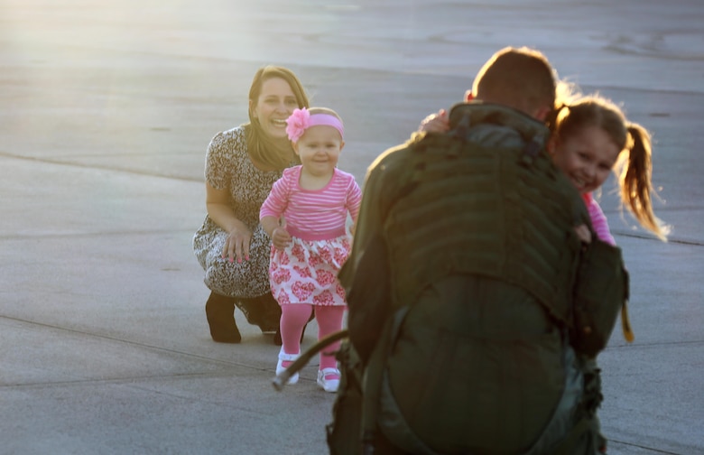 Navy Lt. Thomas Van Brunt is reunited with his family during a homecoming ceremony at Marine Corps Air Station Cherry Point, N.C., Feb. 16, 2016. Marines and Sailors with Marine Tactical Electronic Warfare Squadron 3 returned to the air station after a six-month deployment in support of the United States Pacific Command combatant commander, Marine Aircraft Group 12, 1st Marine Aircraft Wing with EA-6B expeditionary electronic warfare capabilities. Van Brunt is a flight surgeon with the squadron. (U.S. Marine Corps photo by Cpl. N.W. Huertas/Released)
