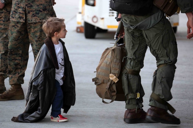 Military member and child with military gear. Cargo pants were developed for the military but are now ubiquitous in the civilian world.