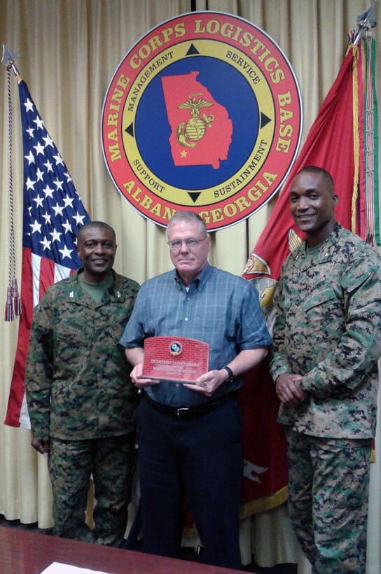 Col. James C. Carroll III (left), commanding officer, Marine Corps Logistics Base Albany, presents Bob James (center), director, Operations and Training Division, MCLB Albany, the Quarterly Safety Award, during the CO’s Quarterly Safety Council Meeting, Feb. 3. Assisted by Lt. Col. Nathaniel Robinson (right), executive officer, MCLB Albany, James accepted the safety award on behalf of the Ops division’s workforce.