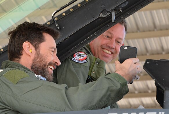Hugh Jackman, “Eddie the Eagle” star, introduces Lt. Col. David Efferson, 457th Fighter Squadron commander and F-16 pilot, to his wife over the phone Feb. 19 during flight preparations here. Jackman received a civic leader flight in an F-16 by the 301st Fighter Wing, an Air Force Reserve unit. (U.S. Air Force photo by Staff Sgt. Samantha Mathison)
