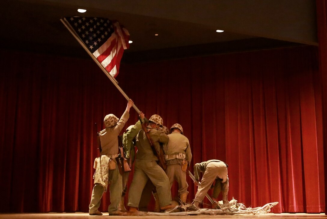 Volunteers reenact the flag raising on Mt. Suribachi during the memorial dinner for the 71st anniversary of the Battle of Iwo Jima, Feb. 20 at Camp Pendleton. During the 36-day battle for the 8.5 square-mile island, 6,821 Marines gave their lives to gain control of the strategic position in the Pacific during World War II. (U.S. Marine Corps photo by Lance Cpl. Caitlin Bevel)
