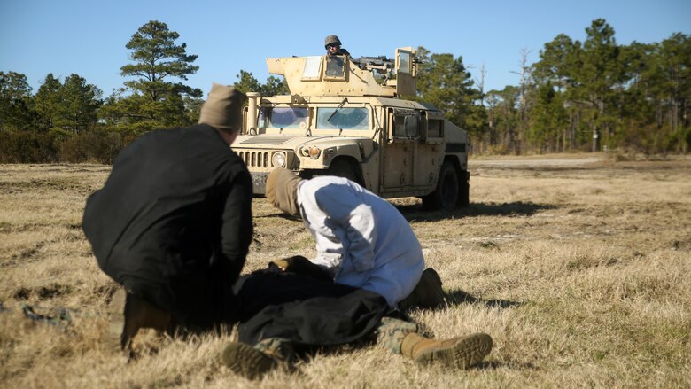 Marines role-playing as the enemy cover a notionally-injured comrade during a convoy operations exercise with Combat Logistics Battalion 6 at Camp Lejeune, N.C., Feb. 11, 2016. The mission of the convoy was to recover a downed vehicle and eliminate potential hostile enemies along their route. (Official Marine Corps photo by Cpl. Joey Mendez/Released)