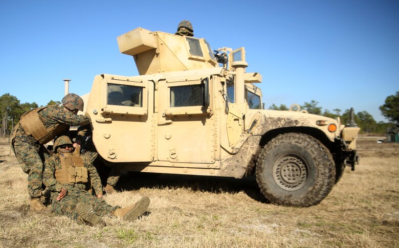 A Marine and corpsman with Combat Logistics Battalion 6 prepare to place Staff Sgt. Christian T. Todd, a platoon sergeant and assistant convoy commander, in a Humvee after he was notionally-injured during a convoy operations exercise at Camp Lejeune, N.C., Feb. 11, 2016. The mission of the convoy was to recover a downed vehicle and eliminate potential hostile enemies along their route. (Official Marine Corps photo by Cpl. Joey Mendez/Released)
