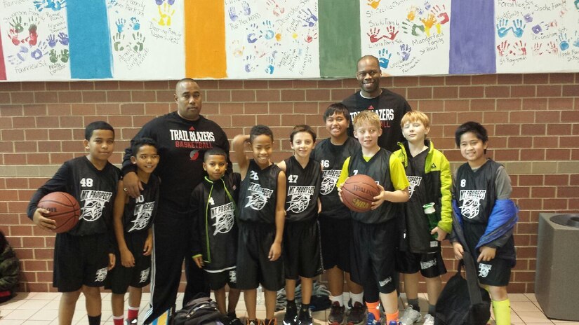 Army Reserve Maj. Lawrence Reid, left, with Sgt. 1st Class Terence Barron pause for a photo with a Mount Prospect Park District youth basketball team after a game. Barron, assigned to the 85th Support Command, also plays semi-professional basketball for the American Basketball Association's Chicago Steam. When he is not working or playing basketball, Barron coaches and mentors youths in playing basketball. He is currently scheduled to play basketball on tour in Beijing, China with the Chicago Steam in May. (Courtesy photo)