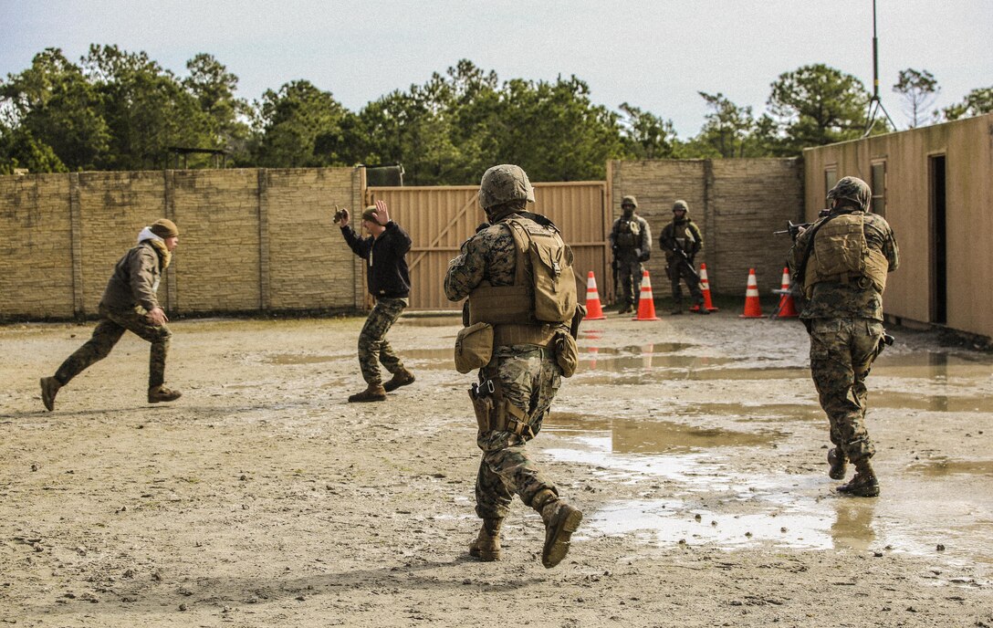 Marines with Bravo Company, 2nd Law Enforcement Battalion, simulate civilians in physical altercations at a forward observation base, which requires Marines to step in and take control of the situation during an interior guard training exercise at Forward Observation Base Hawk at Camp Lejeune, N.C., Feb. 17, 2016. The training prepared Marines to conduct real-life site security operations. (U.S. Marine Corps photo by Lance Cpl. Erick Galera/Released)