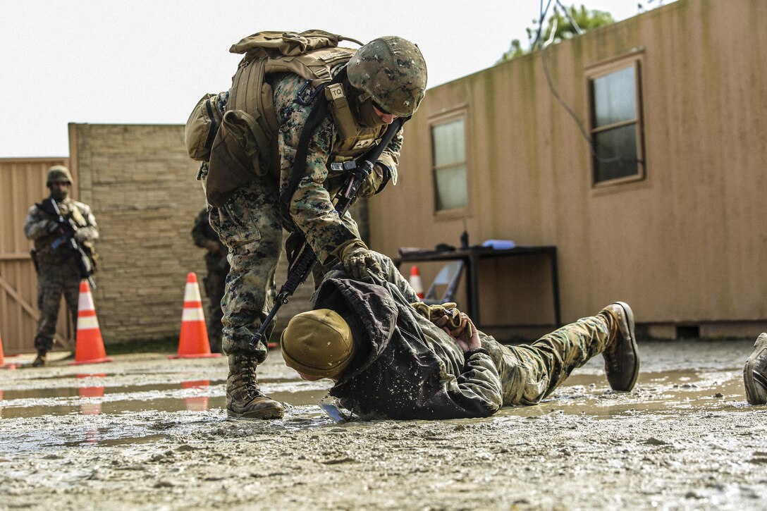 Marines with Bravo Company, 2nd Law Enforcement Battalion, subdue role players after a notional altercations at a forward observation base during an interior guard training exercise at Forward Observation Base Hawk at Camp Lejeune, N.C., Feb. 17, 2016. The training prepared Marines to conduct real-life site security operations. (U.S. Marine Corps photo by Lance Cpl. Erick Galera/Released)