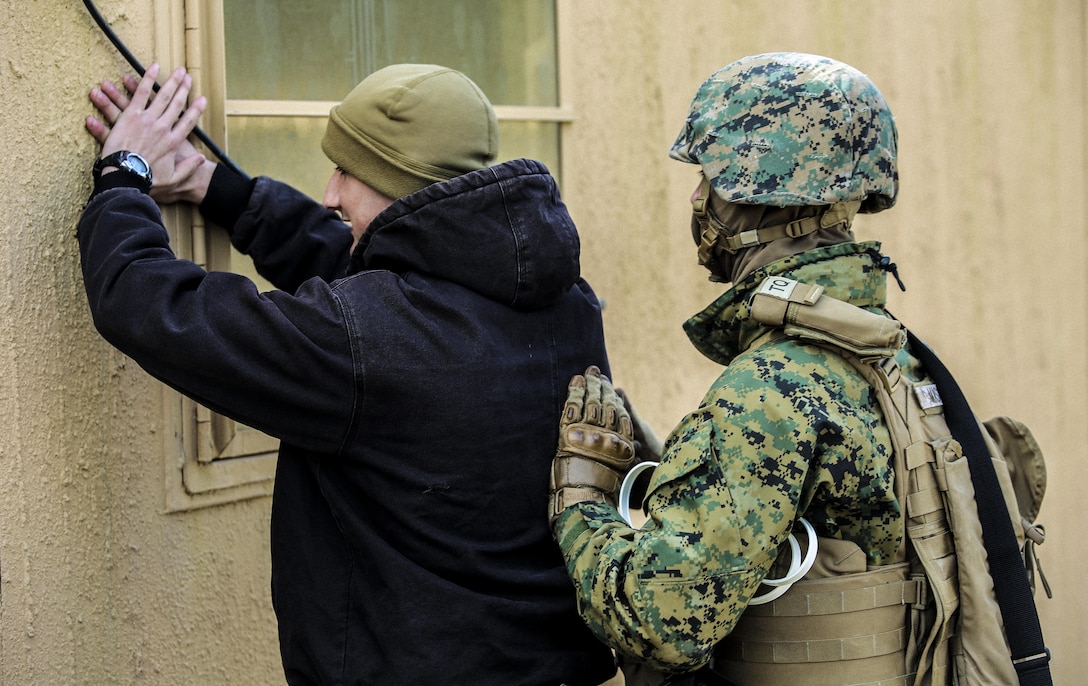 Marines with Bravo Company, 2nd Law Enforcement Battalion, simulate a security check at an entry control point of a forward observation during an interior guard training exercise at Forward Observation Base Hawk at Camp Lejeune, N.C., Feb. 17, 2016. The training prepared Marines to conduct real-life site security operations. (U.S. Marine Corps photo by Lance Cpl. Erick Galera/Released)