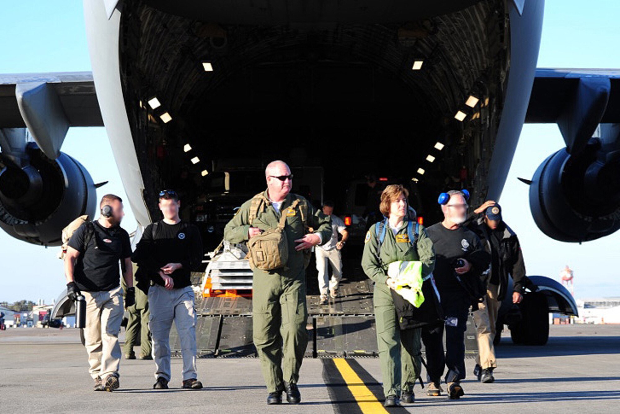 Members of the U.S. Air Force Airlift Control Flight escort members from the FBI Rapid Response Team off of a C-17 Globemaster III during training exercise Patriot Sands Feb. 17, 2016, at Hunter Army Airfield, Georgia. (U.S. Air Force Photo by Senior Airman Jonathan Lane/photo altered to conceal identities of FBI Special Agents)