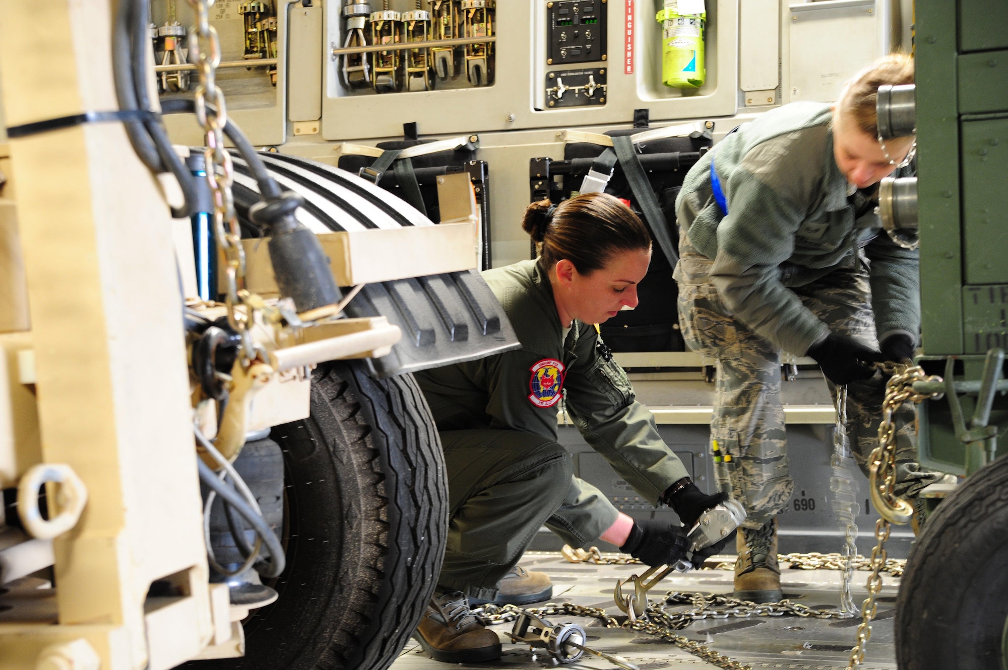 Master Sgt. Marcie Butler, 315th Airlift Control Flight loadmaster, and Senior Airman Della Creech, 81st Aerial Port Squadron, strap down equipment in a C-17 Globemaster III during training exercise Patriot Sands Feb. 17, 2016, at Hunter Army Airfield, Georgia. (U.S. Air Force Photo by Senior Airman Jonathan Lane)