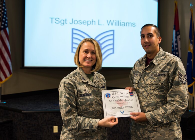 Tech. Sgt. Joseph Williams, 188th Operations Support Squadron weather forecast specialist, accepts the Outstanding Noncommisioned Officer of the Quarter award from Col. Bobbi Doorenbos, 188th Wing commander, Feb. 20, 2016, during a commander’s call at Ebbing Air National Guard Base, Fort Smith, Ark. The Outstanding NCO of the Quarter award is given to NCOs that have provided exceptional service to the wing throughout the last quarter and distinguished themselves among the best in the 188th. Winners were selected in the Airman, NCO, Senior NCO, Company Grade Officer and Field Grade Officer categories. (U.S. Air National Guard photo by Senior Airman Cody Martin/Released)