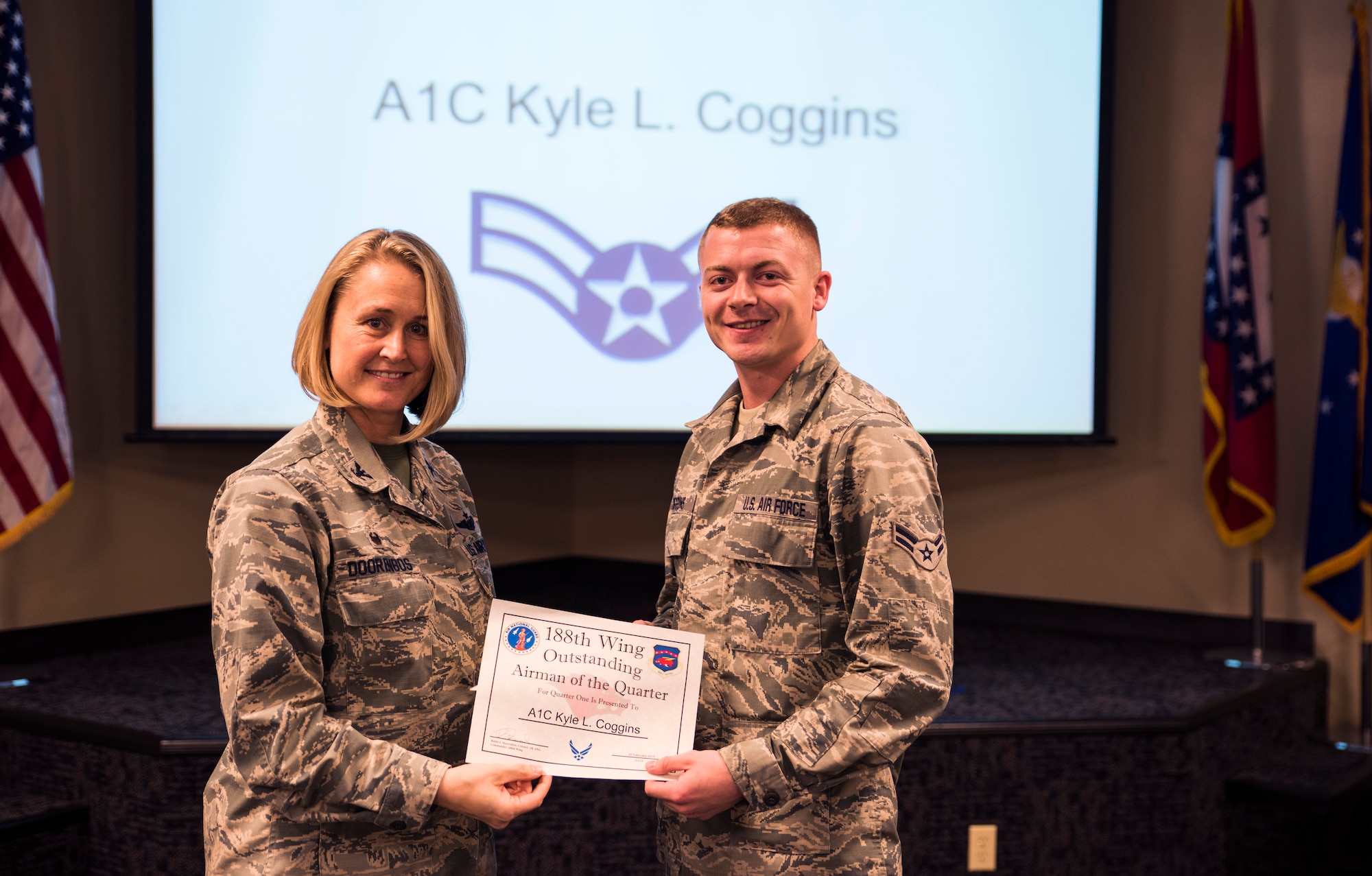 Airman 1st Class Kyle Coggins, 184th Attack Squadron knowledge operations manager, accepts the Outstanding Airman of the Quarter award from Col. Bobbi Doorenbos, 188th Wing commander, Feb. 20, 2016, during a commander’s call at Ebbing Air National Guard Base, Fort Smith, Ark. The Outstanding Airman of the Quarter award is given to Airmen that have provided exceptional service to the wing throughout the last quarter and distinguished themselves among the best in the 188th. Winners were selected in the Airman, Noncomissioned Officer, Senior NCO, Company Grade Officer and Field Grade Officer categories. (U.S. Air National Guard photo by Senior Airman Cody Martin/Released)