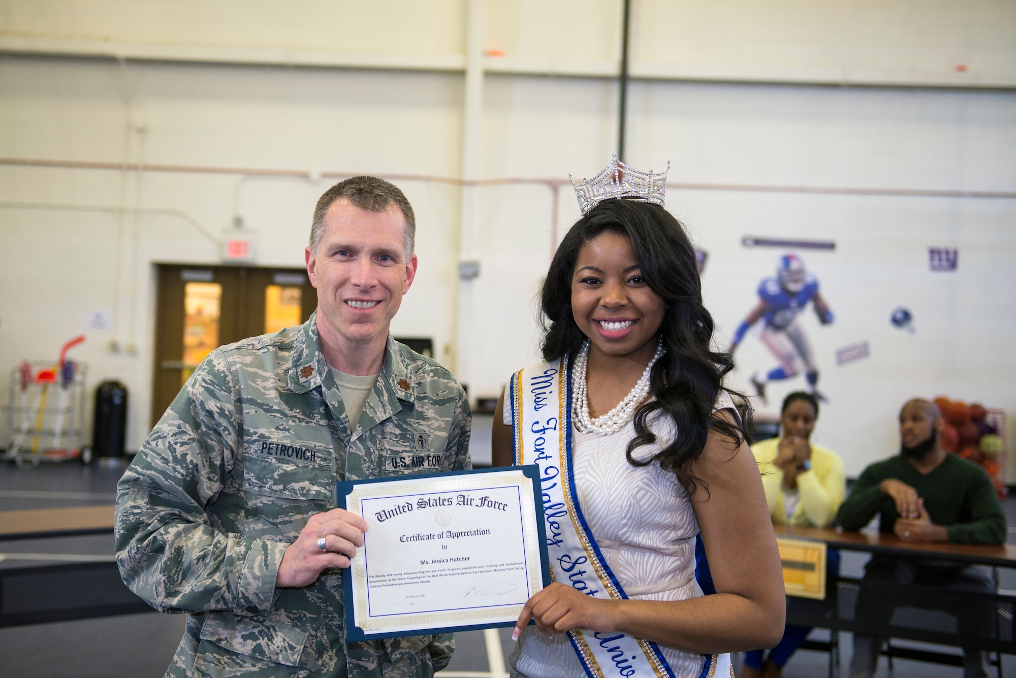 U.S. Air Force Maj. Brian Petrovich, 23d Medical Operations Squadron mental health element chief, presents Jessica Hatcher with a certificate of appreciation during the “Teens Preparing for the Real World” seminar, Feb. 20, 2016, at Moody Air Force Base, Ga. Hatcher, a prior Moody Youth Program teen, spoke to attendees about the benefits of having self-confidence and the importance of a college education. (U.S. Air Force photo by Airman 1st Class Greg Nash/Released)  