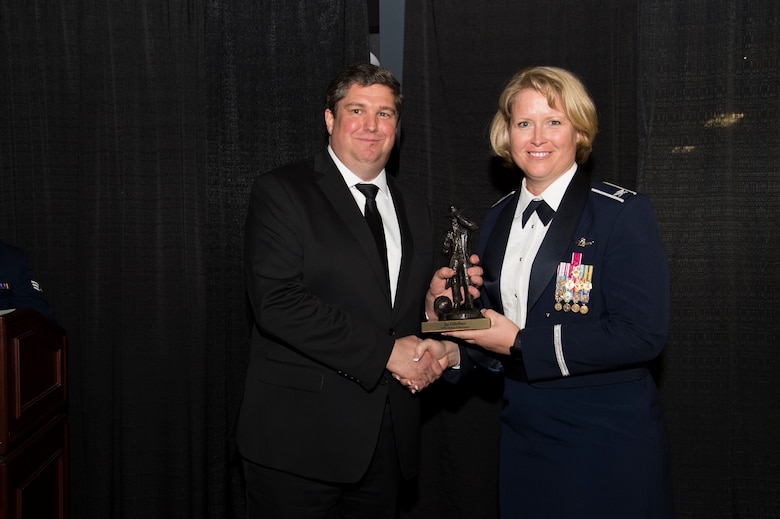 Col. DeAnna M. Burt, 50th Space Wing commander, presents the GPS Lifetime Achievement to Jay Uebelhart during the second annual GPS Heritage Gala Friday, Feb. 19, 2016, at the Space Foundation in Colorado Springs, Colorado. Uebelhart received the award for his continued 30 years of service to the success of GPS mission. (U.S. Air Force photo/Tech. Sgt. Julius Delos Reyes)