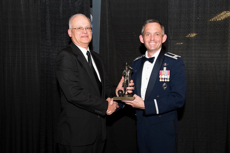 Col. Damon Feltman, 310th Space Wing commander, presents the 2015 Greatest Contribution to GPS Launch to Marc Drake during the second annual GPS Heritage Gala Friday, Feb. 19, 2016, at the Space Foundation in Colorado Springs, Colorado. Drake received the award for his role in the launches of GPS SVN 71, 72 and 73. (U.S. Air Force photo/Tech. Sgt. Julius Delos Reyes) 
