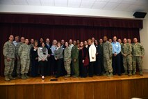Team McChord leadership and Honorary Commanders pose for a group photo after the Team McChord Honorary Commander change of command at the Chapel Support Center Feb. 22, 2016, at Joint Base Lewis-McChord, Wash. From the tangible donations to the behind the scenes interaction and support of Airmen, the community plays a huge role in the success of military installations worldwide. (U.S. Air Force photo/Staff Sgt. Naomi Shipley)