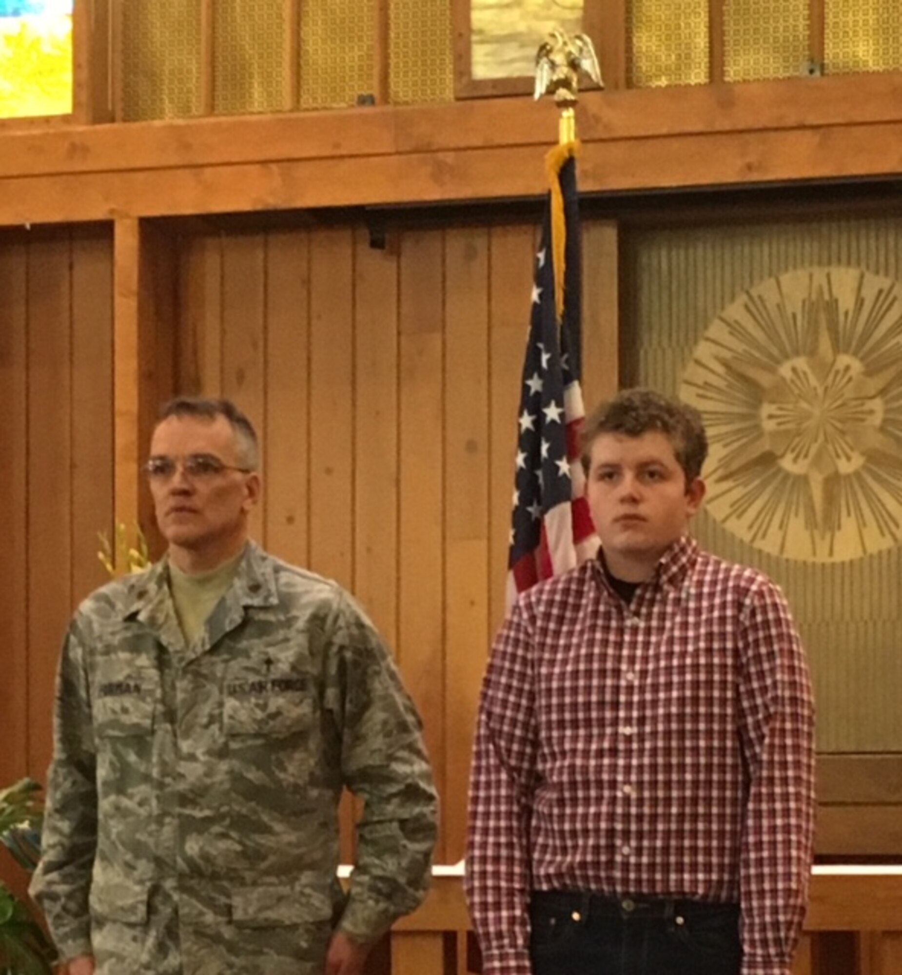 PETERSON AIR FORCE BASE, Colo. – Chaplain (Maj.) Daniel Forman, 21st Space Wing deputy chaplain and Ethan Boarts, son of deployed 21st SW Chaplain (Lt. Col.) Matthew Boarts, stand at attention during a mock pinning ceremony Feb. 2, 2016 in the Peterson Chapel. The event marking Boarts’ promotion was held to bring together the family who experienced multiple personal tragedies as well as a deployment in a short time. (Courtesy photo)