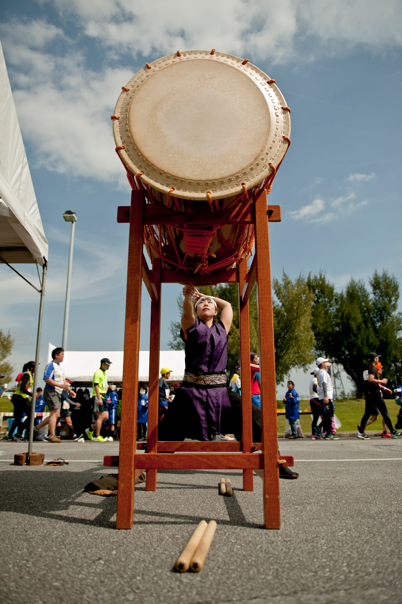 A Soukan Taiko member beats on an Okedo-daiko instrument to cheer on runners during the Okinawa Marathon Feb. 21, 2016, at Kadena Air Base, Japan. Various Okinawan organizations arrived on Kadena to rally runners reaching the marathon's 31-kilometer mark. (U.S. Air Force photo by Senior Airman Peter Reft)
