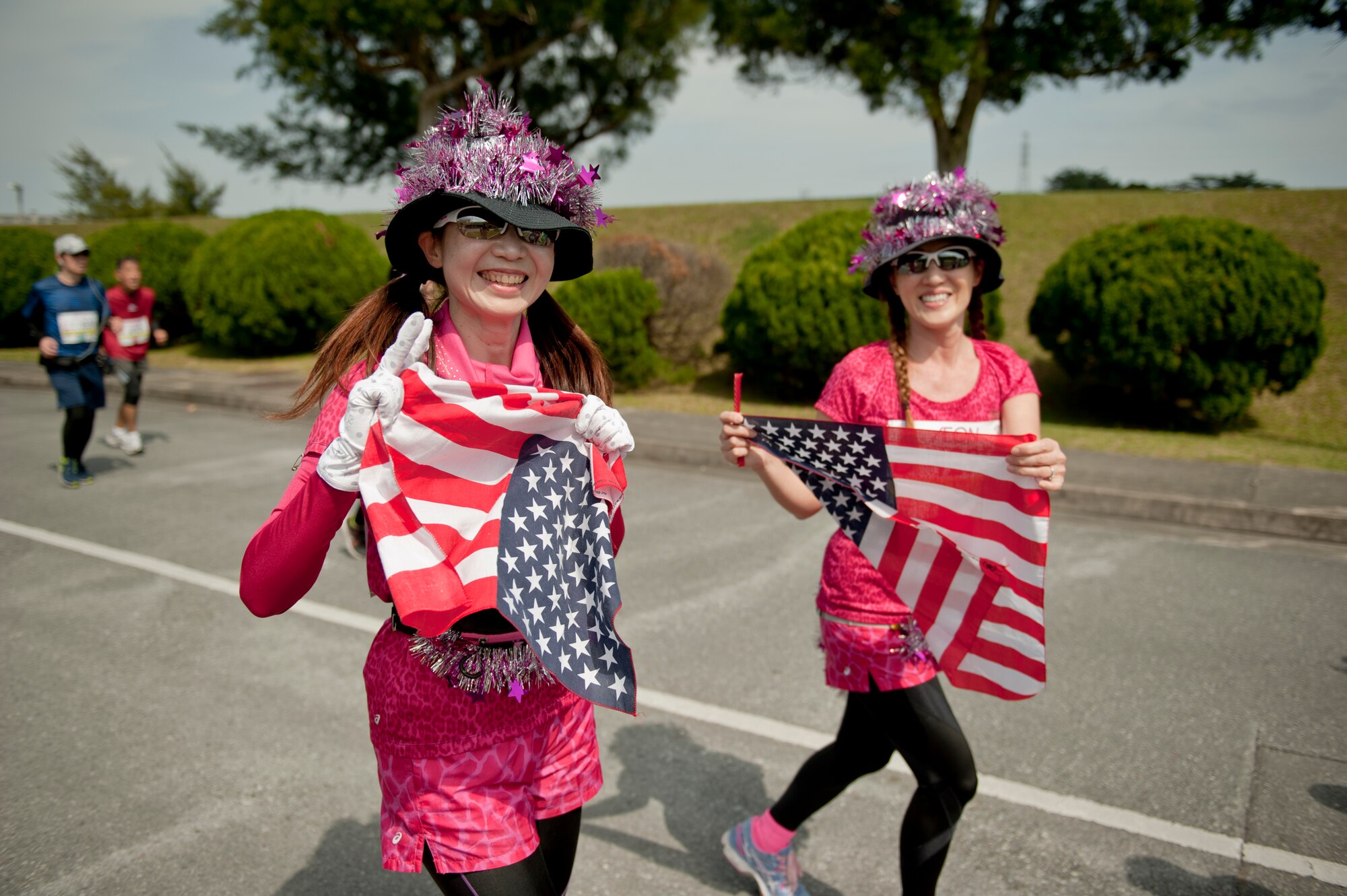 Runners carry U.S. flags during the Okinawa Marathon Feb. 21, 2016 at Kadena Air Base, Japan. The Okinawa Marathon is unique since it is the only Japanese marathon to feature a section of the route on a military installation. (U.S. Air Force photo by Senior Airman Peter Reft) 